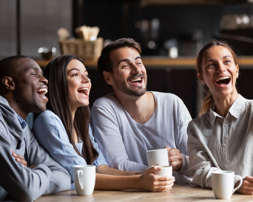 A diverse group of young adults are smiling with their mouths agape. 